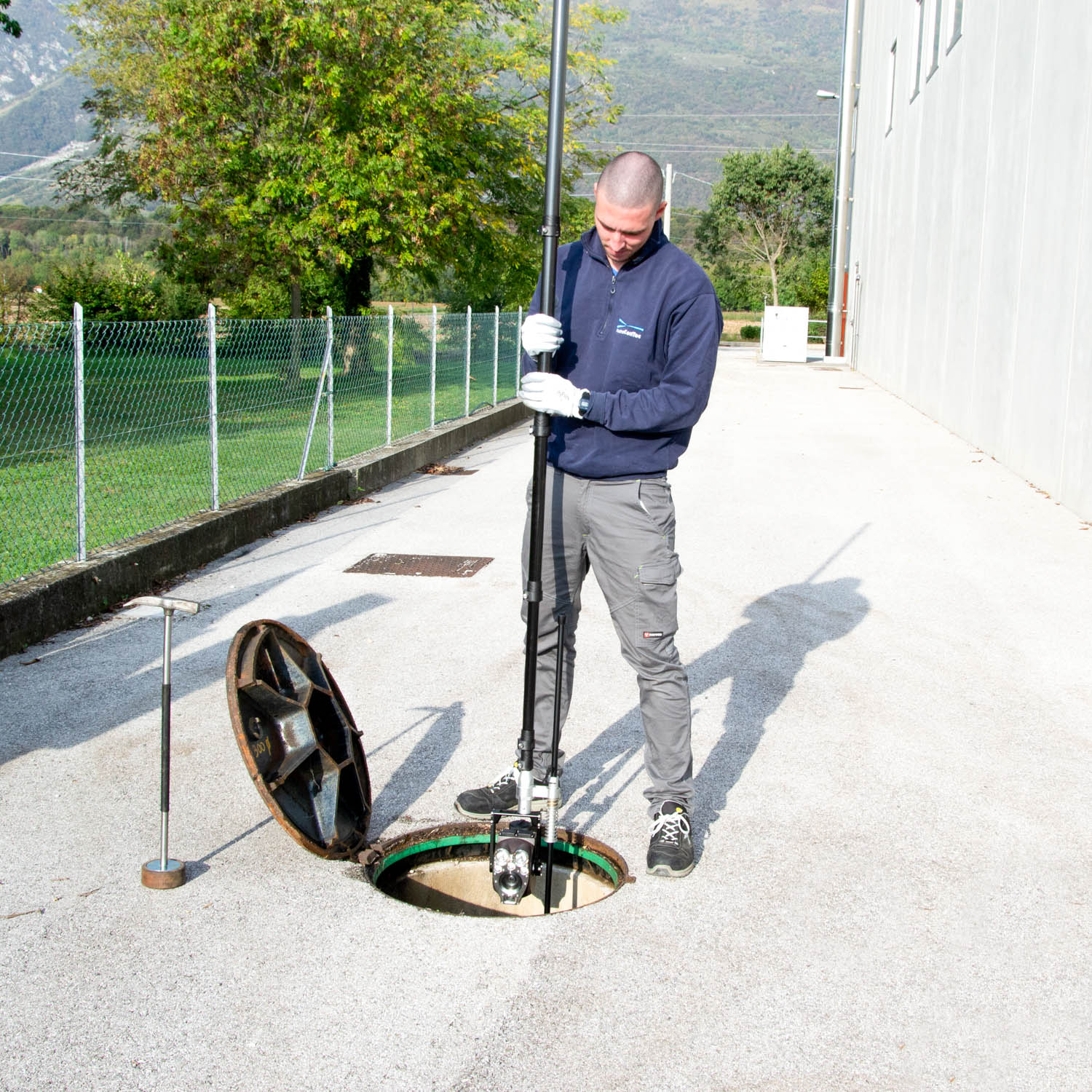 Francesco Gabelli inserisce il periscopio Xplorer all'interno del pozzetto per effettuare la videoispezione