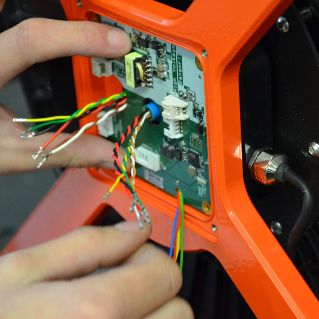 Mani impegnate in una procedura di riparazione tecnica su prodotti MiniCam